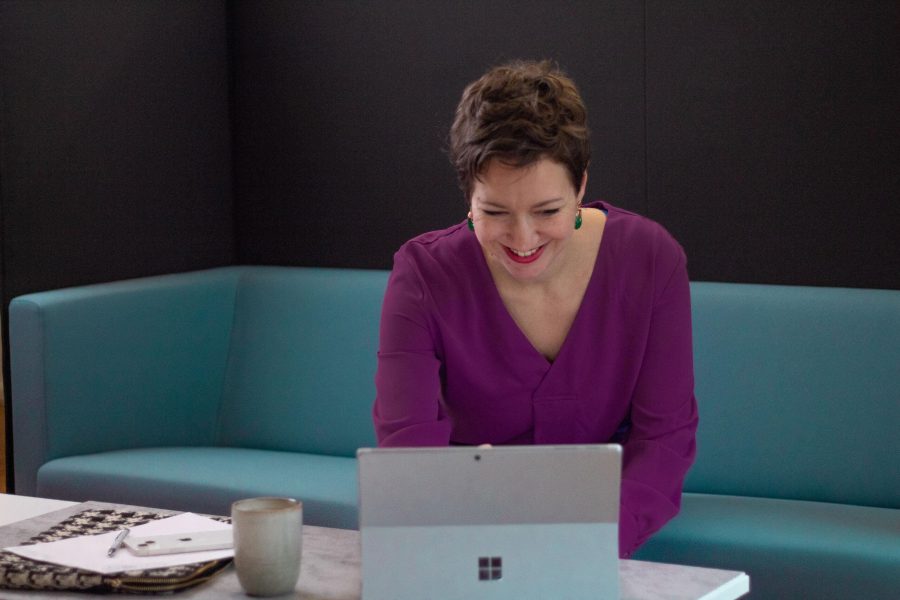 Dame sitzt vor Laptop und liest Evergreen Content im Marketing